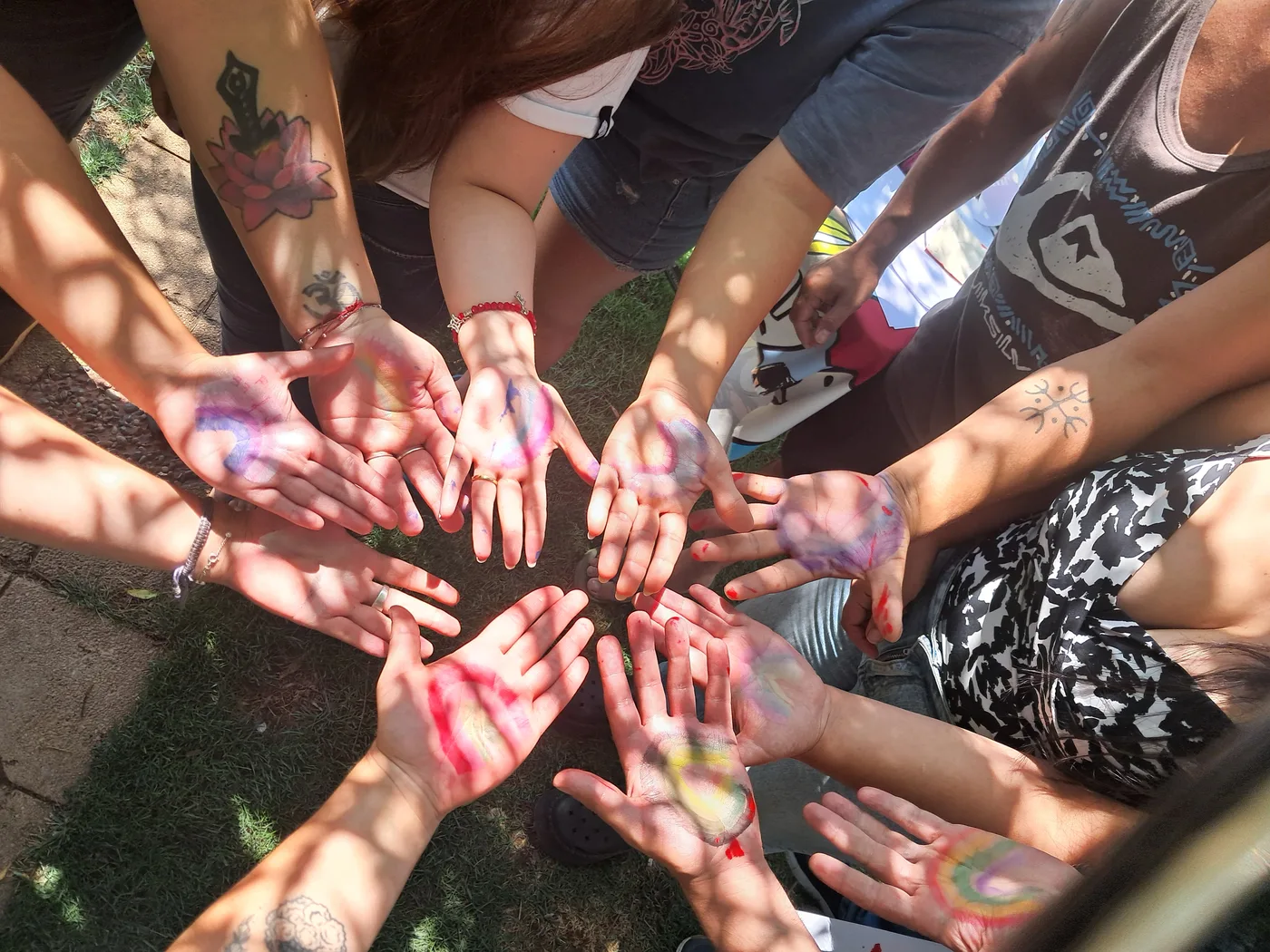 Manos con palmas pintadas reunidas en círculo durante una jornada creativa
